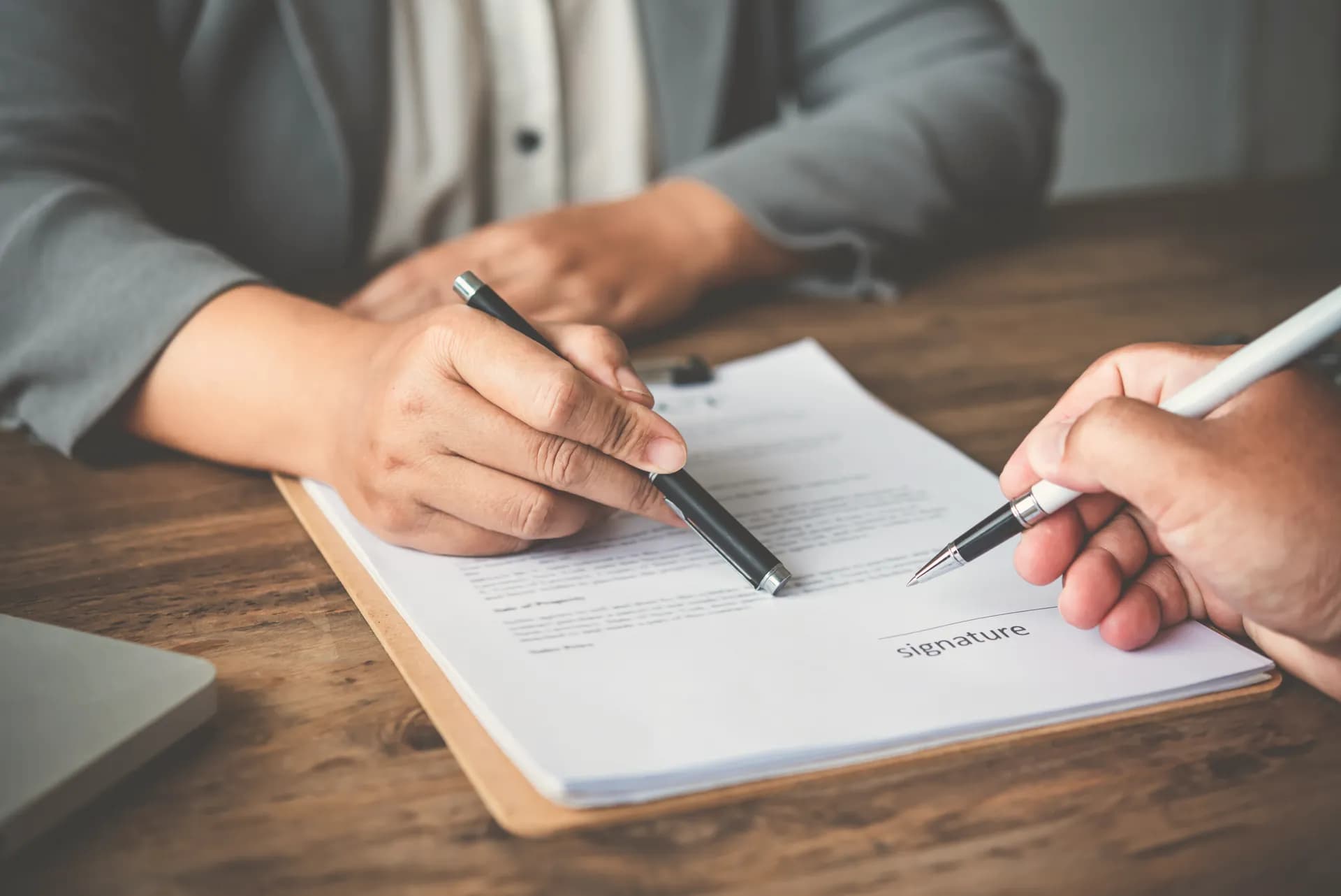 Two people going through a document before it is signed